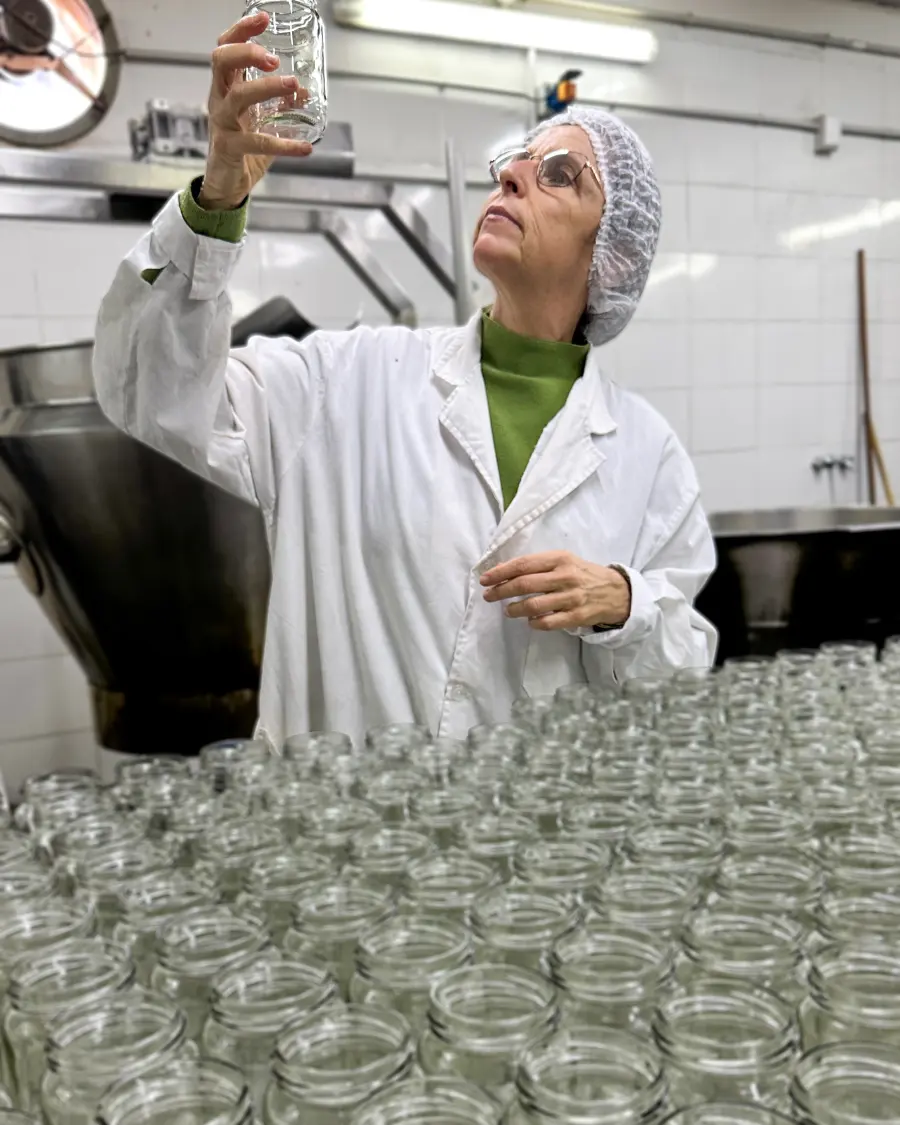 Giselle evaluando frascos en una fábrica